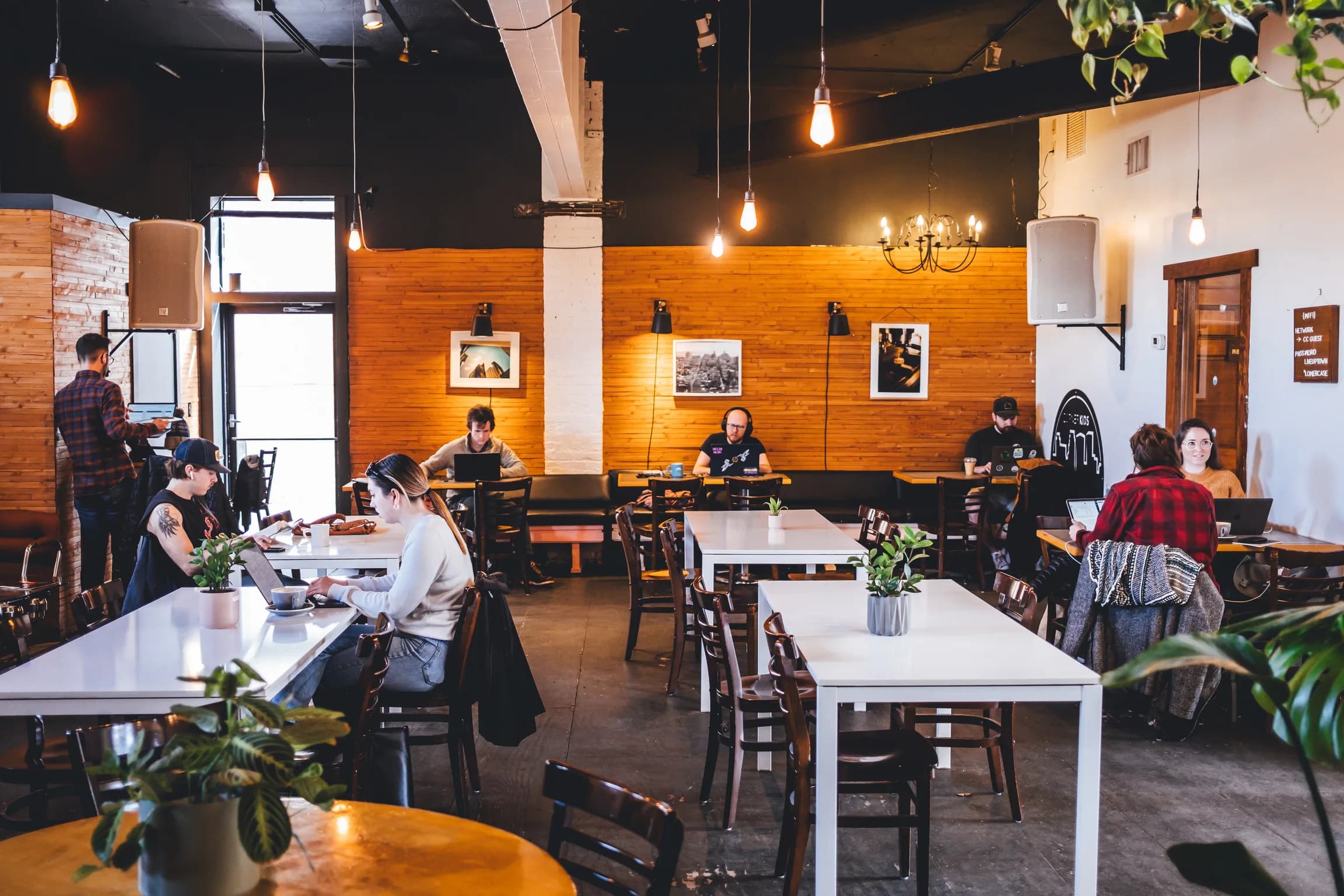 Corner Coffee Uptown seating area with guests working under warm pendant lights